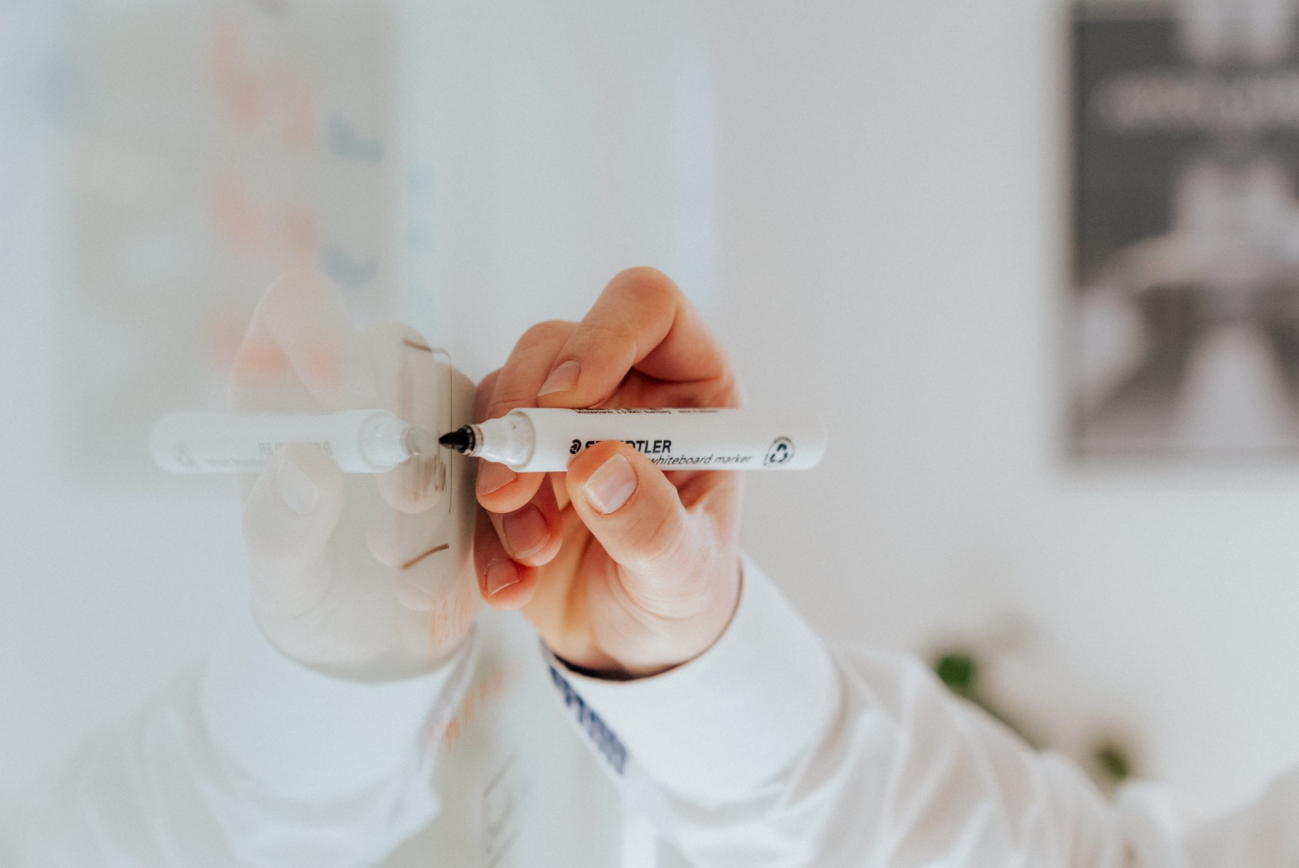 Mitarbeiter mit Blatt und Stift, der in Dokumenten liest, symbolisiert sorgfältige Analyse, Planung und präzise Beratung – Werte, die Medoplan bei der Praxisnachfolge und -beratung auszeichnet.